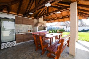 an outdoor kitchen with a wooden table and chairs at Apartment Vujovic in Kladovo