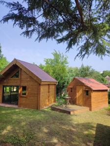 a log cabin with a picnic table next to a house at L'ETAPE PARIS-FONTAINEBLEAU in Pringy