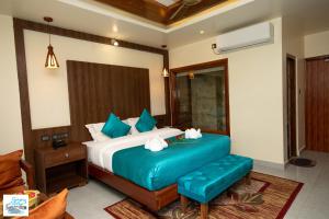a bedroom with a large bed with blue pillows at KC's Home in Sauraha