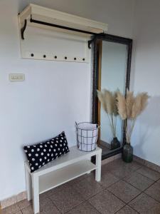 eine Bank neben einer Wand mit einem Spiegel in der Unterkunft Apartment Gabriela in Rakovica