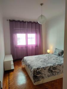 a bedroom with a bed and a purple window at A place to rest and enjoy in Piedade