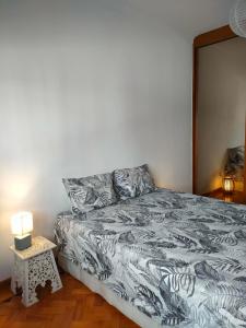 um quarto com uma cama e uma mesa com um candeeiro em A place to rest and enjoy em Piedade