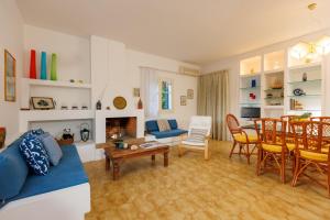 Una sala de estar con un sofá, una mesa y sillas. en Villa in the Garden, en Kokkíni Khánion
