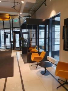 un vestíbulo con sillas y mesas amarillas en un edificio en Loft Style Studio Apartment- Free Parking- Free Gym- Keyless Access en Tartu