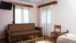 ein Wohnzimmer mit einem Sofa und einem Bett in der Unterkunft Fani's House Under Meteora in Kastraki