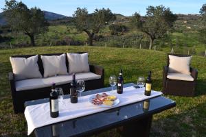 uma mesa com um prato de alimentos e garrafas de vinho em Podere dei maddii em Roccastrada