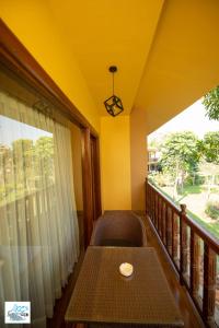 a table sitting on a balcony with a window at KC's Home in Sauraha