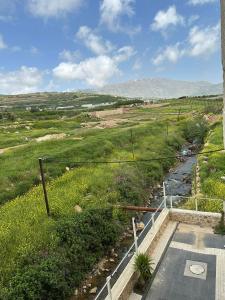uma vista para um campo com um rio em Goland Hotel em Mas'ada