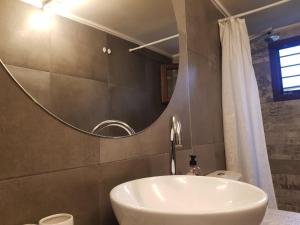 uma casa de banho com um lavatório e um espelho em Loft house 2 em Ormos Panagias