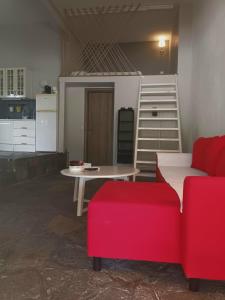uma sala de estar com uma mesa e um sofá vermelho em Loft house 2 em Ormos Panagias