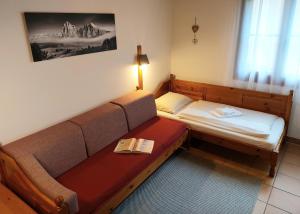 a room with a couch and a bed with a book at Apartment Gerlitzen Garden in Treffen