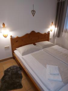 a bed with white sheets and pillows in a bedroom at Apartment Gerlitzen Garden in Treffen