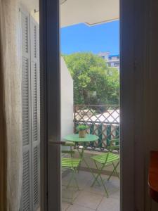 a door leading to a balcony with a table at Chez Chebil in rue Halevy - near the sea in Nice