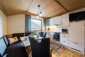 a kitchen and living room with a table and chairs at Bauernhof Ferienwohnungen Sennhof in Weerberg