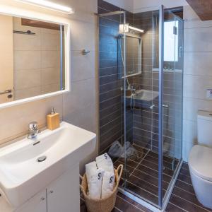 a bathroom with a shower and a sink and a toilet at Syra Bay in Megas Yialos-Nites