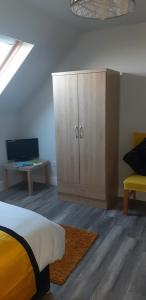 a bedroom with a bed and a cabinet and a desk at Cherry blossom. In Erris 