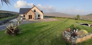 a house in the middle of a green field at Cherry blossom. In Erris 