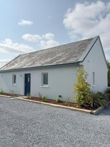 a white house with a gravel driveway at The Cottage - Fairwinds in Doolin