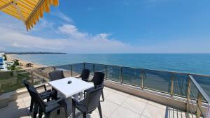 a balcony with a table and chairs and the ocean at Diamond Beach Luxus Apart Obzor 28 in Obzor
