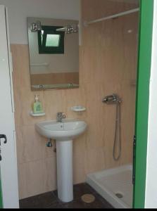 La salle de bains est pourvue d'un lavabo, d'un miroir et d'une baignoire. dans l'établissement Juncalillo Garden, à Las Palmas de Gran Canaria