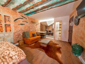 sala de estar con sofá y pared de piedra en Domus Lapidis - Ibera en Bogarra