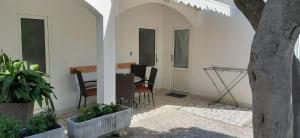 a patio with chairs and a table in a house at Rooms & Apartments Kaurloto in Pag