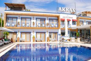 ein Hotel mit einem Pool vor einem Gebäude in der Unterkunft Akkan Beach Hotel in Bodrum City