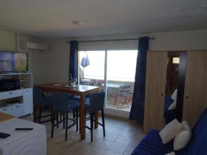 un salon avec une table de salle à manger avec vue sur l'océan dans l'établissement T2 Alba Rossa n 141 Confort, Panorama Mer Incroyable, à Serra-di-Ferro