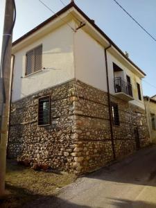 a stone building with a stone wall at Traditional House "Elisavet" in Próti