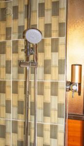 a shower in a bathroom with a tile wall at Little Amanya Camp in Amboseli