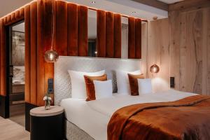 a bedroom with a large white bed with brown pillows at Der Eisvogel - Wellness- & Genusshotel in Bad Gögging