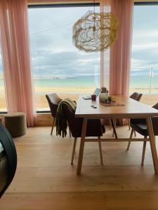 a dining room with a table and a view of the beach at Ekkerøy Lodge - Arctic luxury in Vadsø