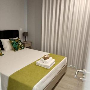 um quarto com uma cama com uma toalha em Ancoradouro T1 - Alojamento Local Gerês em Braga