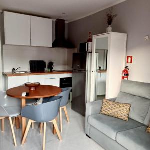 uma sala de estar com uma mesa e um sofá e uma cozinha em Ancoradouro T1 - Alojamento Local Gerês em Braga