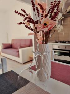 een vaas met bloemen erin zittend op een tafel bij Attico con terrazzo Relax in Ladispoli