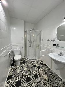 a bathroom with a shower and a toilet and a sink at Hotel Park in Opoczno