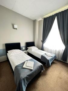 um quarto de hotel com duas camas e uma janela em Hotel Park em Opoczno