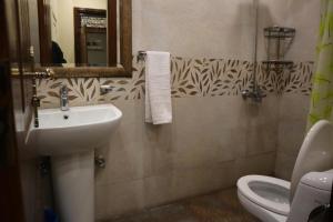 GO Luxury Grand Hotel في لاهور: حمام مع حوض ومرحاض ومرآة