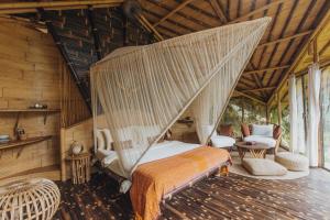a bed in a room with a mosquito net at Hideout Bali in Selat