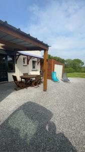 a patio with a picnic table and a building at LE CHANT DES OISEAUX arrivée autonome in Sorbais