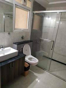 uma casa de banho com um chuveiro, um WC e um lavatório. em 2 BHK Corporate Service Apartment Manyata Tech Park em Bangalore