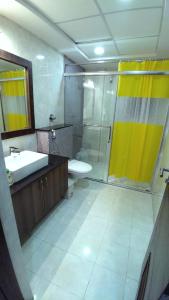 uma casa de banho com um chuveiro, um lavatório e um WC. em 2 BHK Corporate Service Apartment Manyata Tech Park em Bangalore