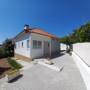 una pequeña casa blanca con entrada en Casa da Ti Emília en Cardigos