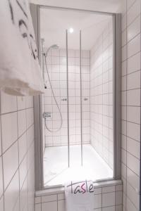 a shower with a glass door in a bathroom at Taste Hotel Jettingen in Jettingen-Scheppach