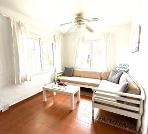 a living room with a couch and a table at Ca Mestral Son Bou Urbanización típica menorquina. in Son Bou