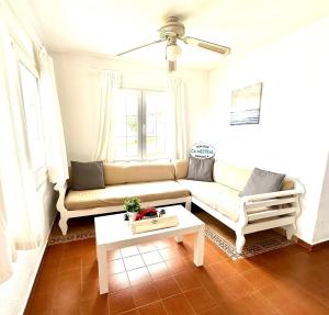 a living room with a couch and a table at Ca Mestral Son Bou Urbanización típica menorquina. in Son Bou
