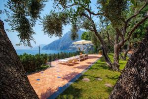 a patio with a bench and an umbrella and the water at La Villa Positano - Luxury villa with private sea access in Positano