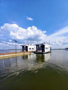 a boat is docked at a dock in the water at ARKA 2 domki na wodzie w Mielnie 400 metrów do morza, rower wodny, Wifi, Parking in Mielno