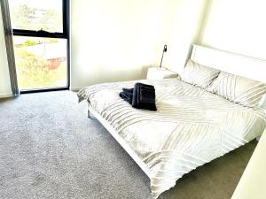 Un dormitorio con una cama con una bolsa negra. en Modern 2 bedroom & 2 bathroom apartment with stunning Sydney CBD & Skyline Views!, en Liverpool