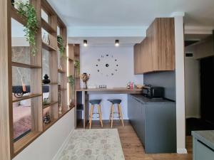 eine Küche mit einer Theke und Stühlen in der Unterkunft Panorama Deluxe Aparthotel in Cluj-Napoca